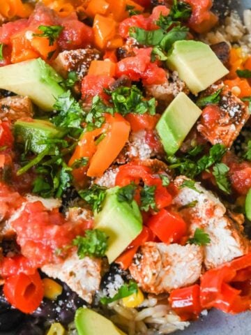 close up shot of southwest chicken bowl topped with cilantro and avocado.