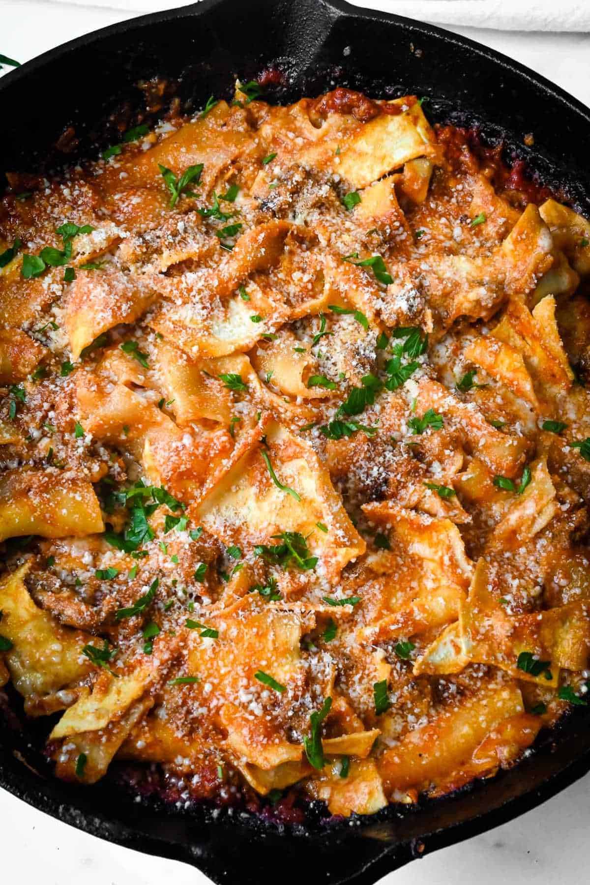 cast iron skillet of no-boil lasagna topped with parsley.