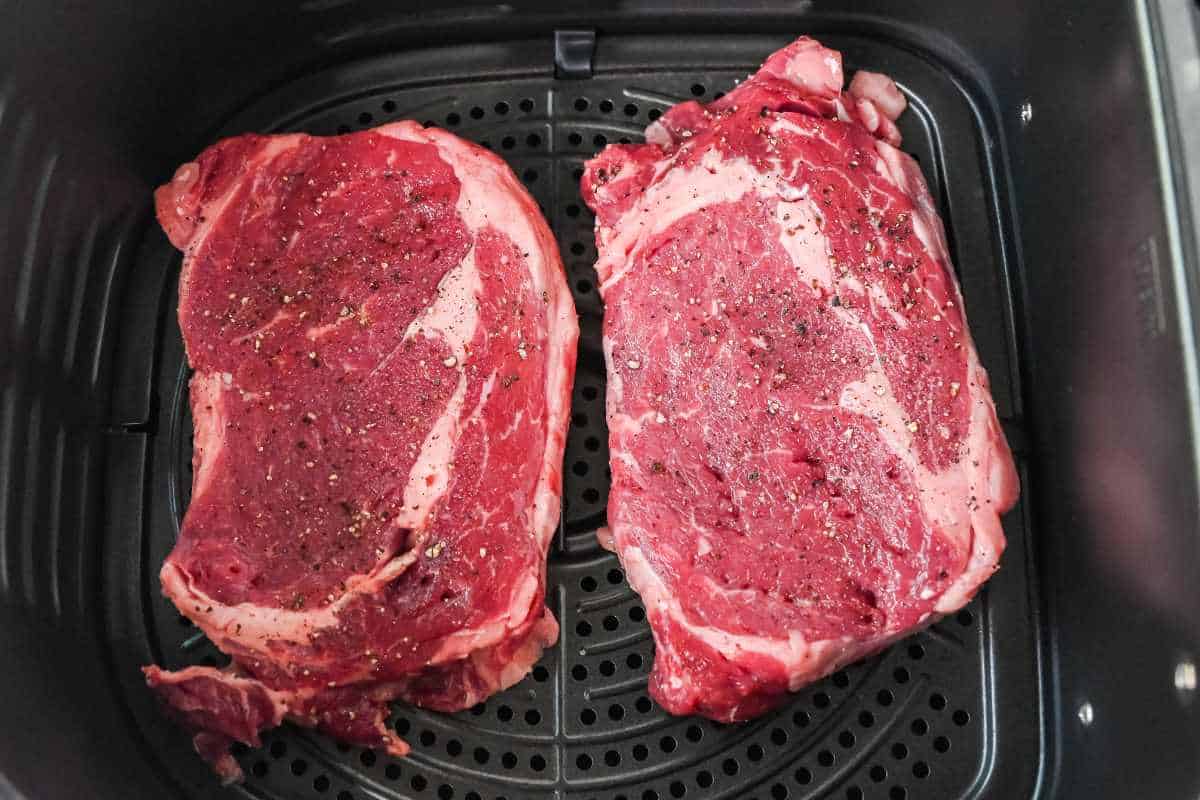 raw ribeye steak in an air fryer.