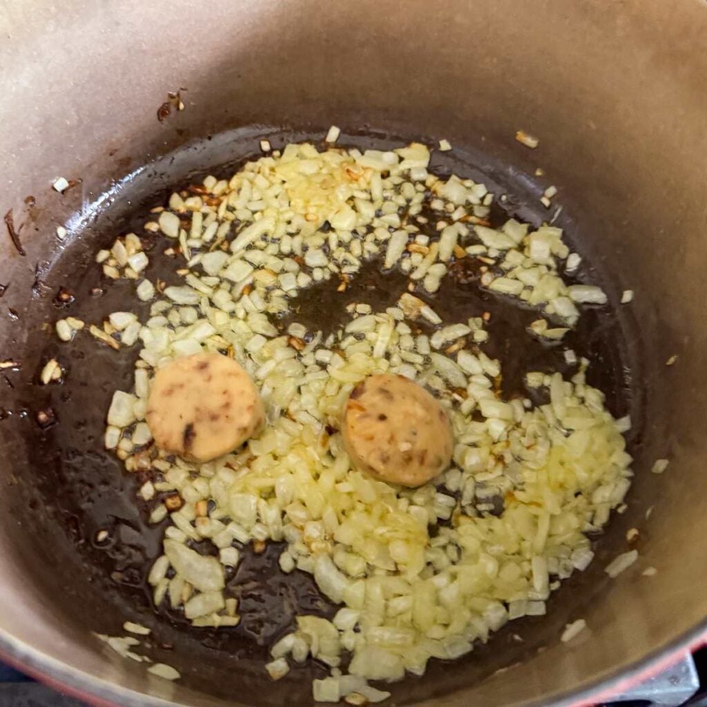 shallots and garlic simmering in a pan.