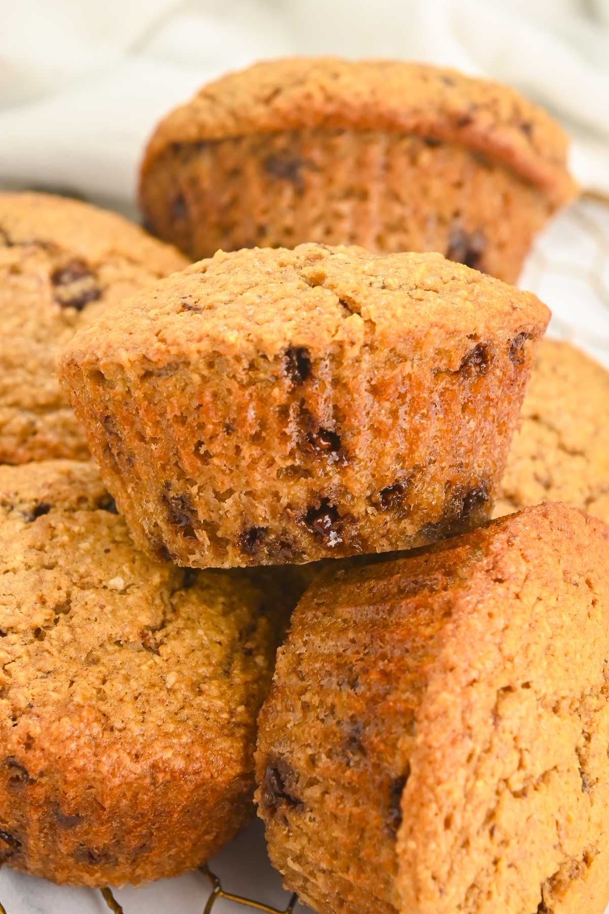 close up of one chocolate chip cookie muffin in a pile.